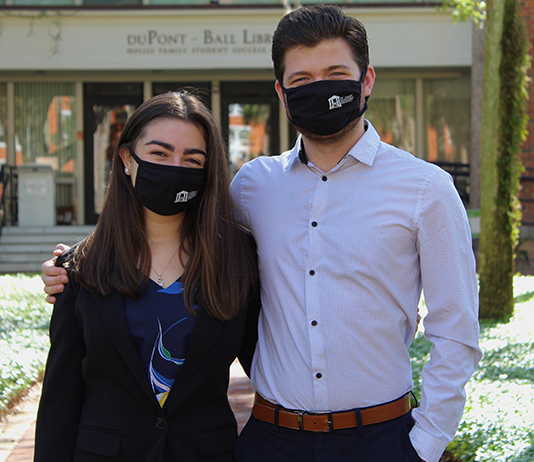 The two SGA officers wear facial coverings in front of duPont-Ball Library.