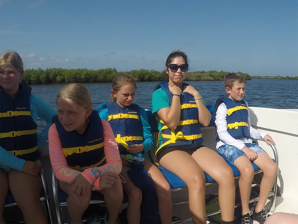 Verania Sosa and a group of kids ride on a pontoon boat.