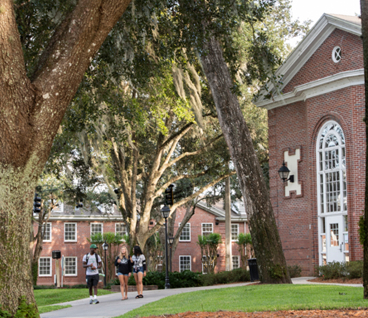 3 students walk across campus.