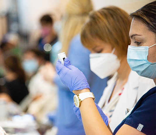 Nurses wear face coverings at on-campus vaccination clinic for COVID-19.