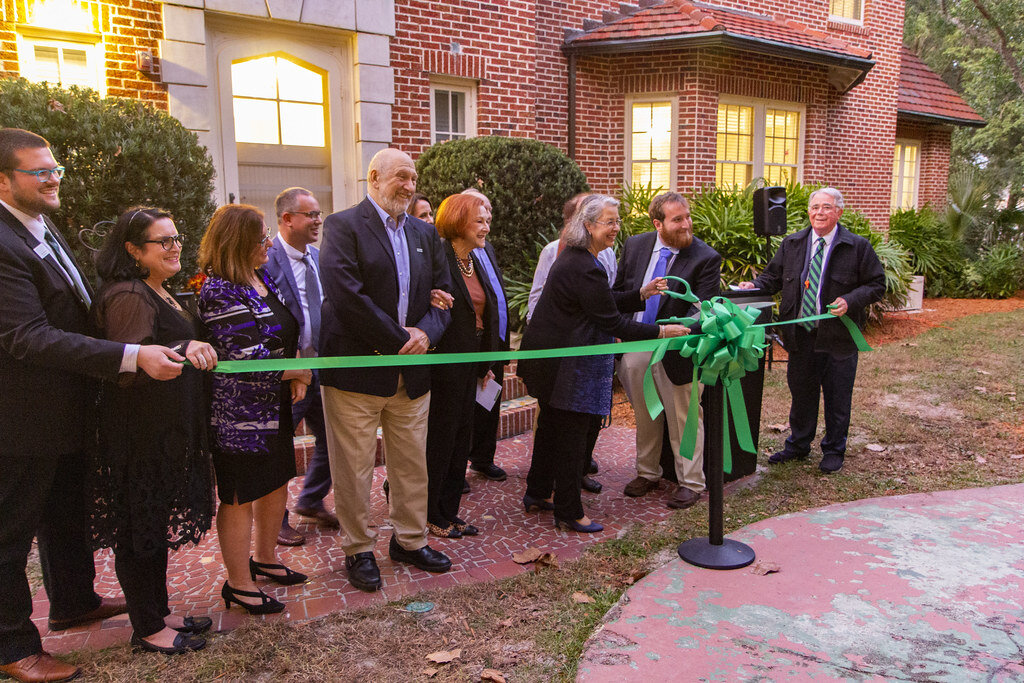 A small crowd gathers to cut a ribbon on the new Stetson Hillel House in 2019.