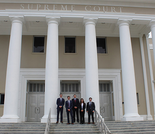 A small group stands in front of the Florida Supreme Court