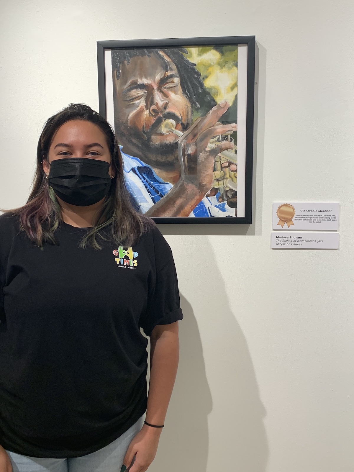 A student stands beside her artwork, which received an Honorable Mention in the 2021 student exhibition