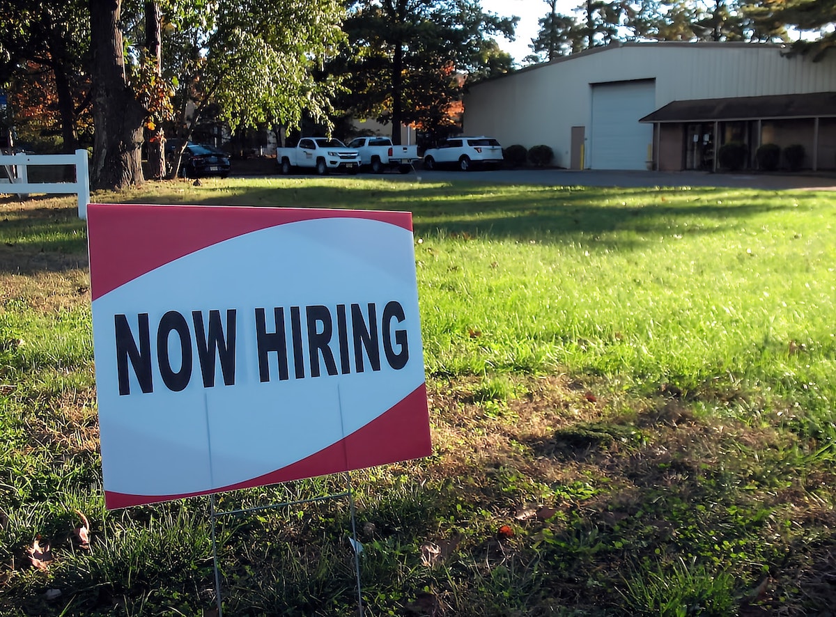 Now Hiring sign is in front of a business.