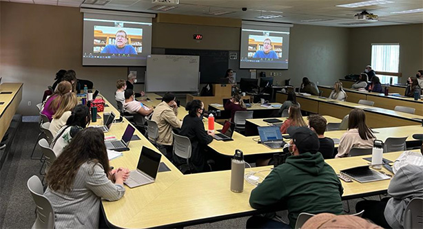 Photo of law class listening to virtual guest speaker David Rivkin on screens