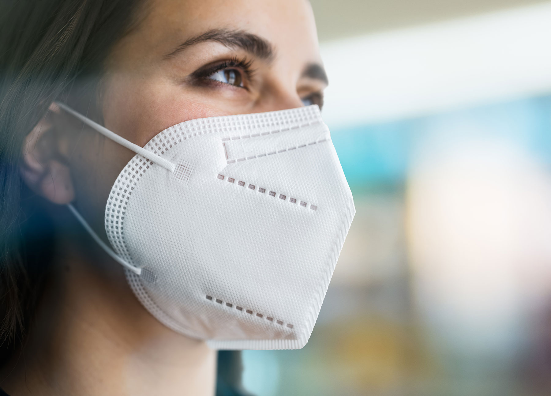 A woman wears a N95 / KN95 respirator for COVID.