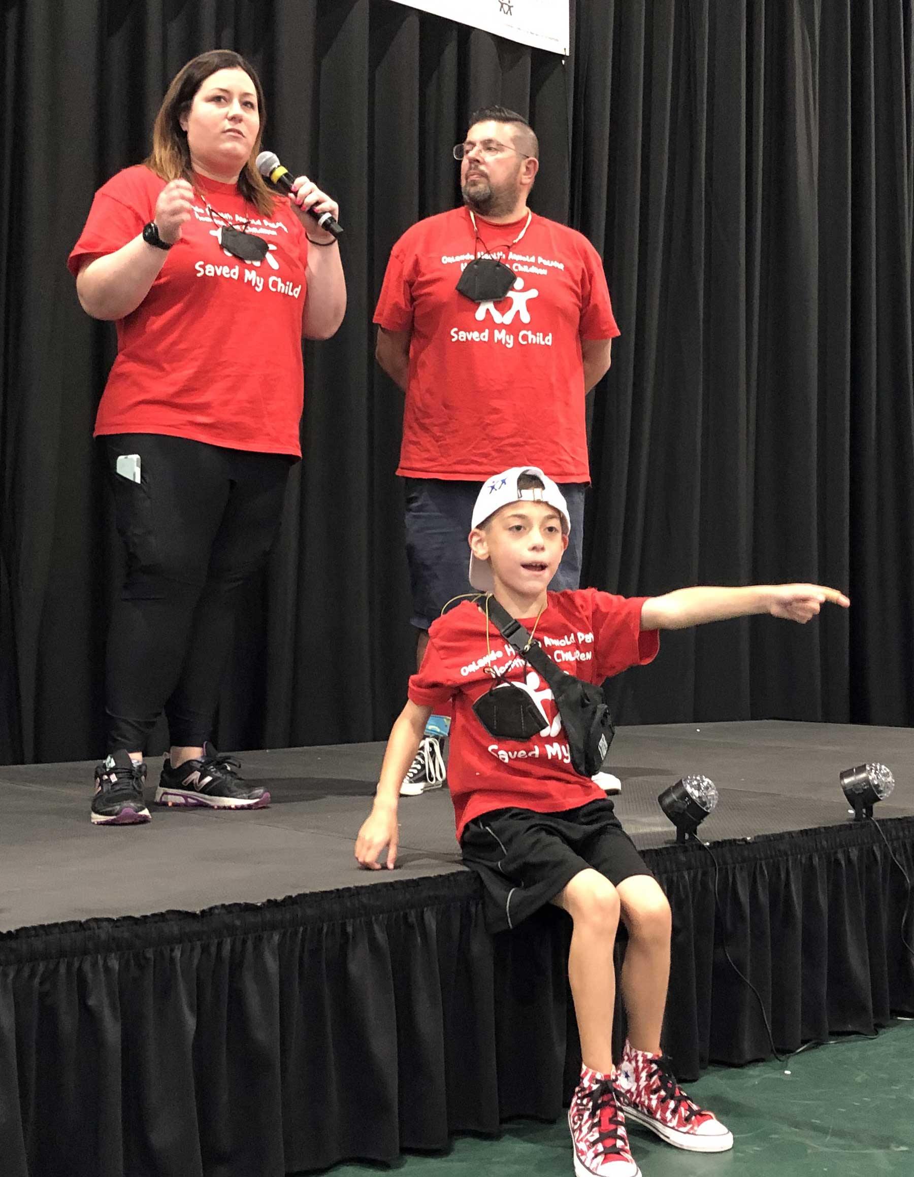 Mom is talking on stage with husband and son beside her at Hatterthon