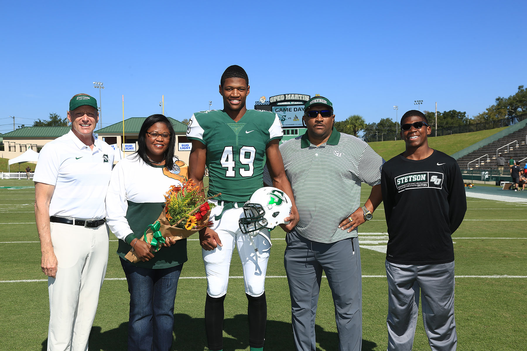 Donald Parham, the football coach and his family pose on the field.