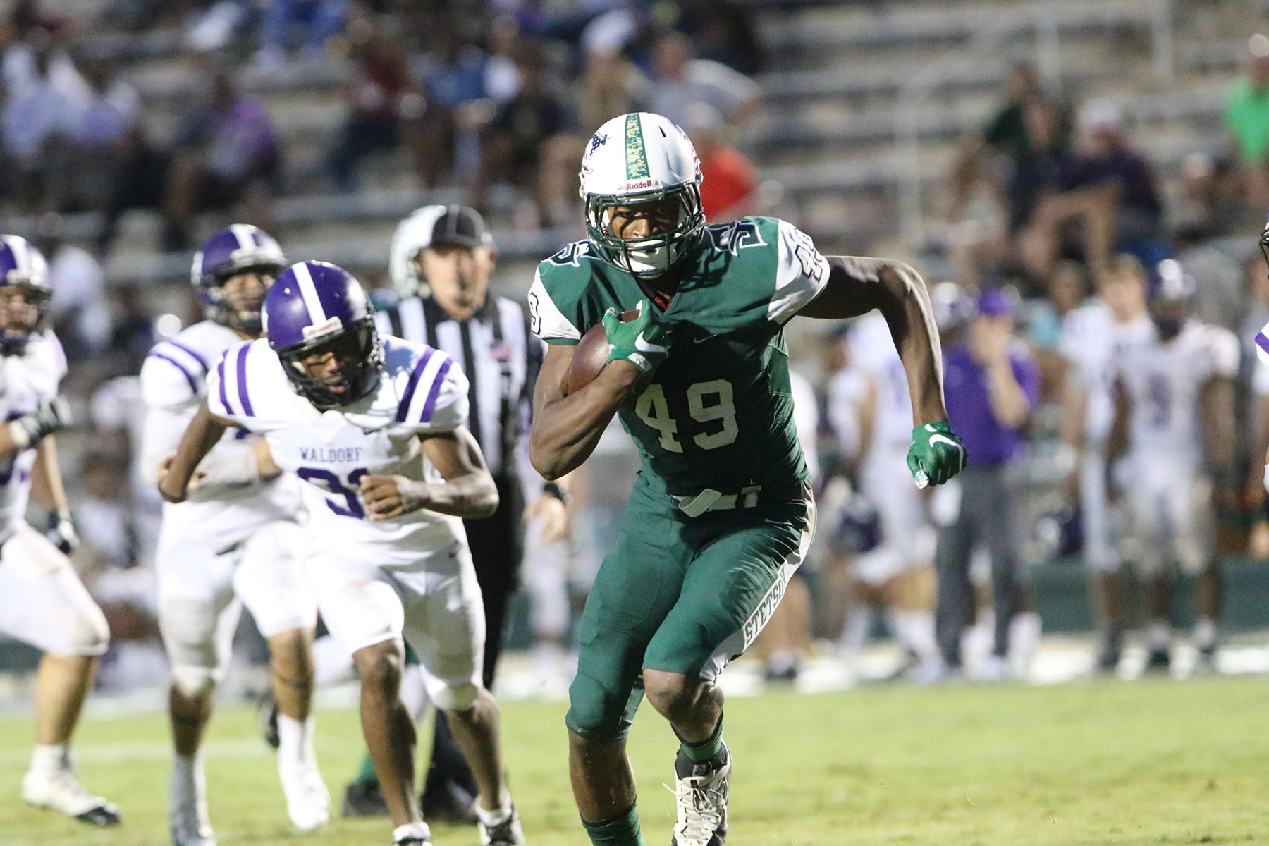 Donald Parham runs on the football field with several players in pursuit