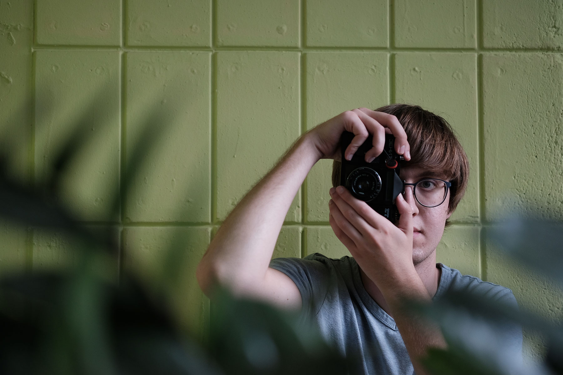 Jacob Mauser looks through a camera viewfinder