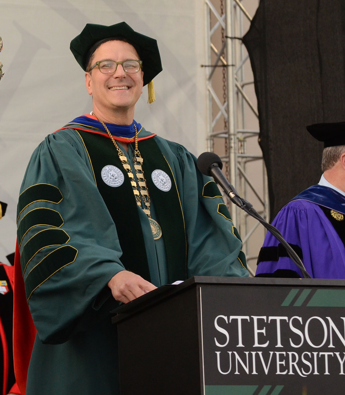President Roellke stands at a podium during Graduate Commencement 2022.
