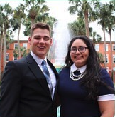 The two pose in front of the fountain.