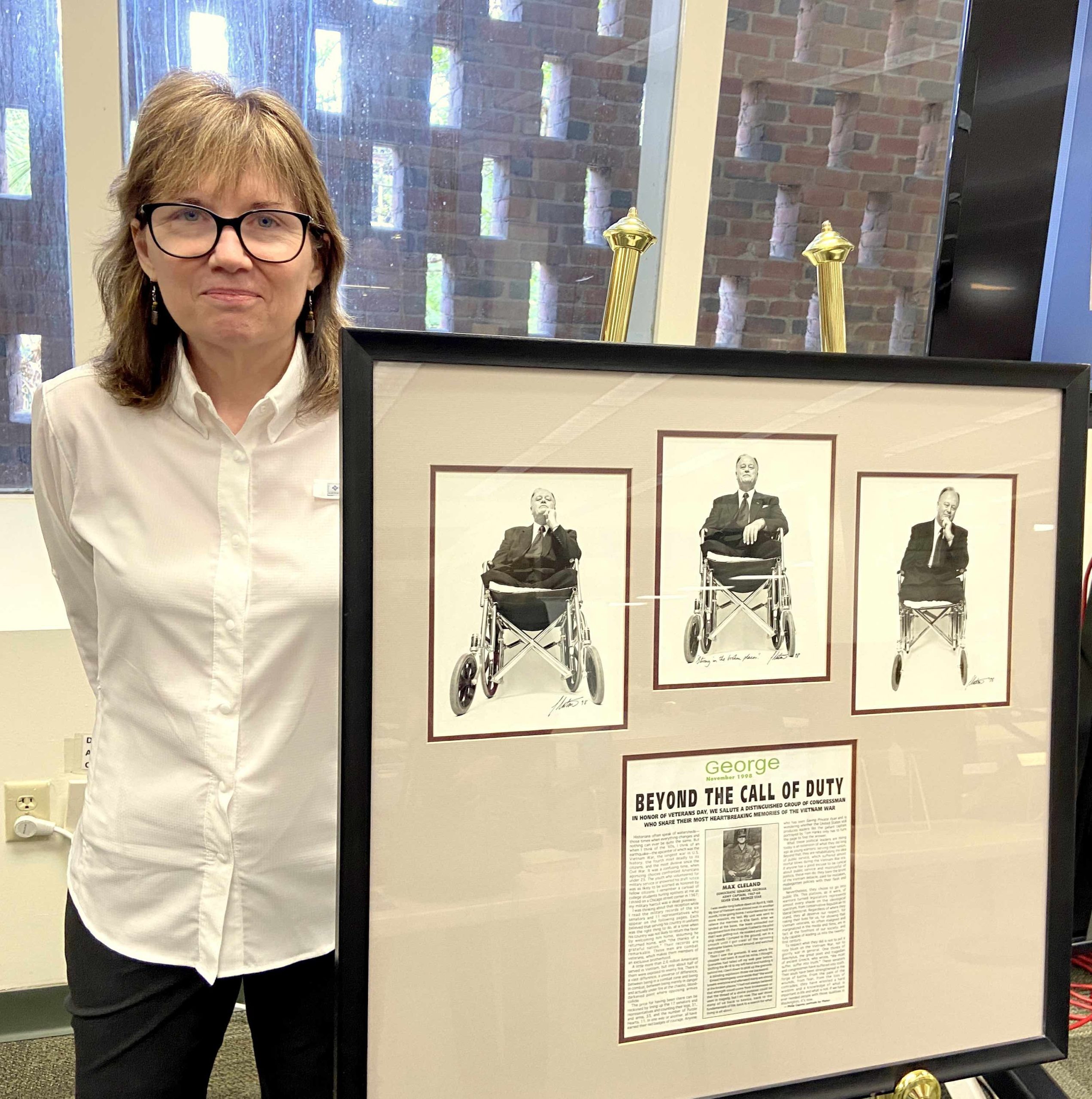 Sue Ryan stands beside a framed photo of 