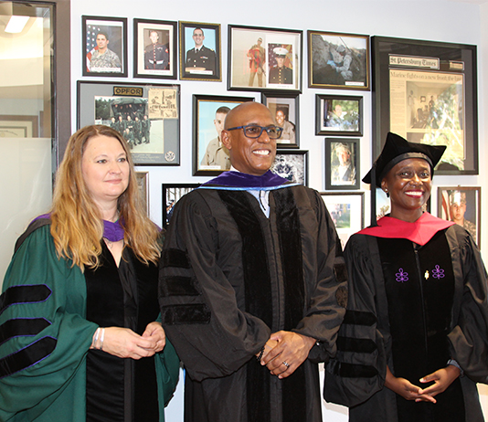 Three people pose in the Veterans Law Institute