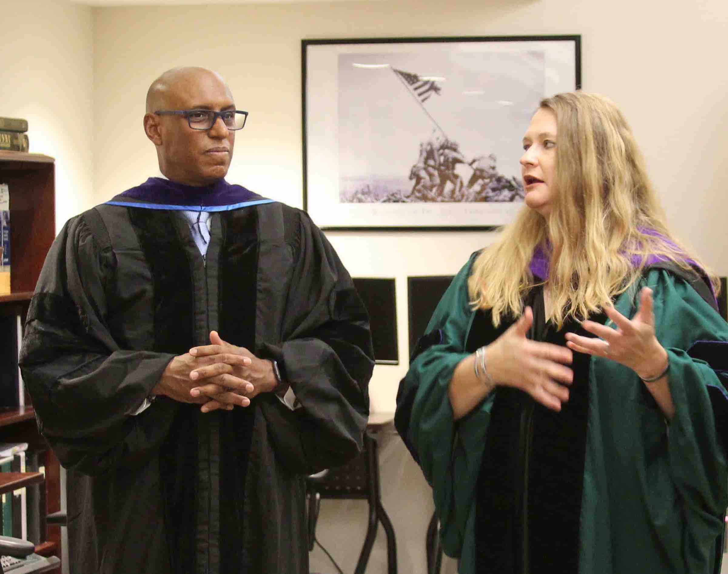 Two people stand talking in the Veterans Law Institute