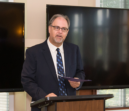 Portrait of Dr. Mike Bitter standing at a podium.