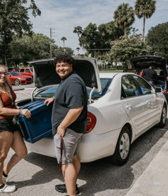 Two people stand at the trunk of car unloading on Move-In Day 2022