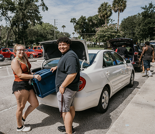 Two people stand at the trunk of car unloading on Move-In Day 2022