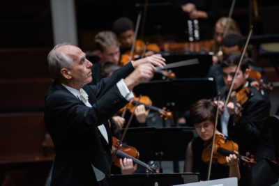 A conductor leads the orchestra