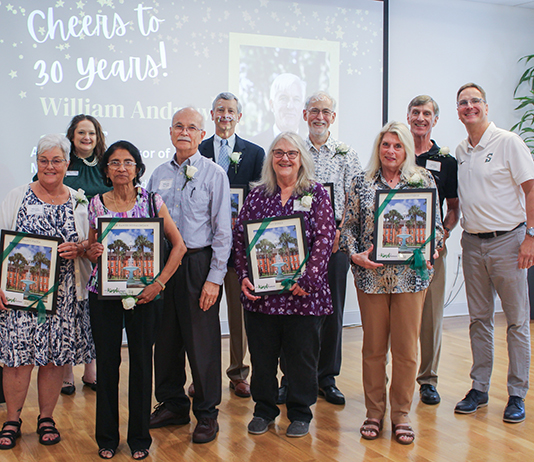 Group of people standing celebrating 30 years of service to Stetson.