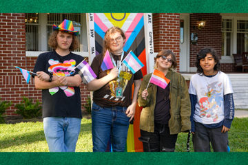 A group of students stand in front of the Coming Out Door for Kaleidoscope's gay pride events in October 2024.