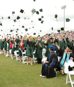 Graduates throw their caps in the air after the Commencement ceremony