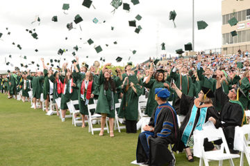 Graduates throw their caps in the air after the Commencement ceremony
