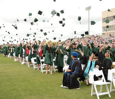 Graduates throw their caps in the air after the Commencement ceremony