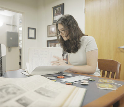 A woman conducts research in library archives