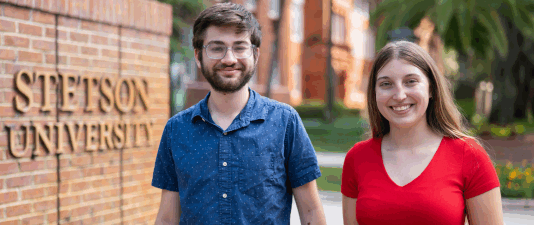 Two students stand in front of the Stetson gates