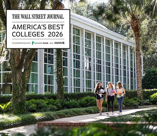 Three students walk past an academic building with a graphic that says Wall Street Journal's Best Colleges 2026