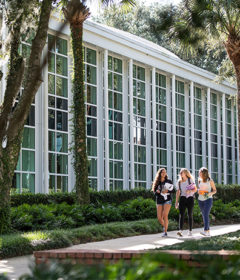 Three students walk by an academic building