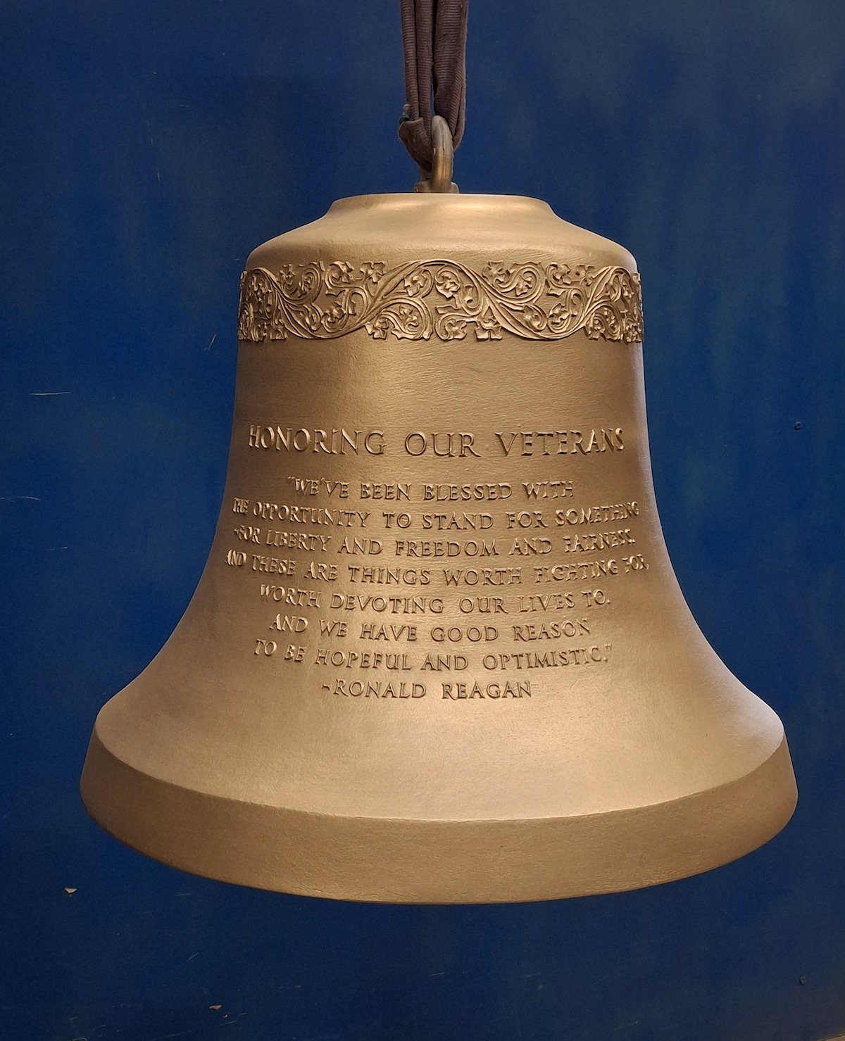 A large cast bell is inscribed with text