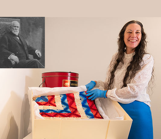 A woman displays a quilt