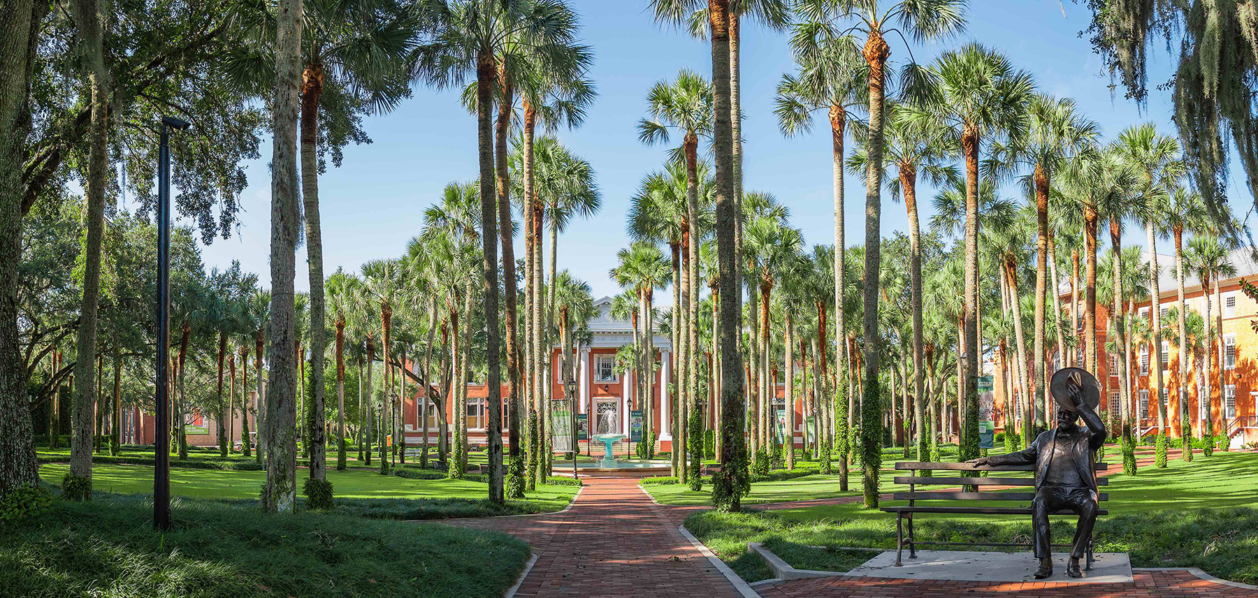 Scenic photo of Palm Court with palm trees and a fountain.
