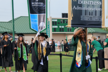Graduates walk outside at Commencement