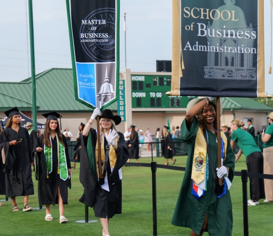 Graduates walk outside at Commencement