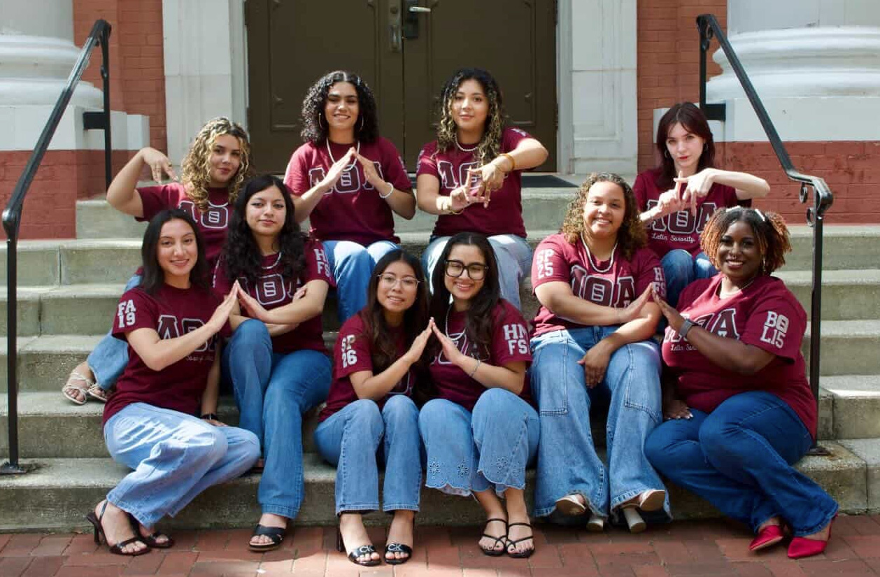 Group photo of women seated on the steps of a building.
