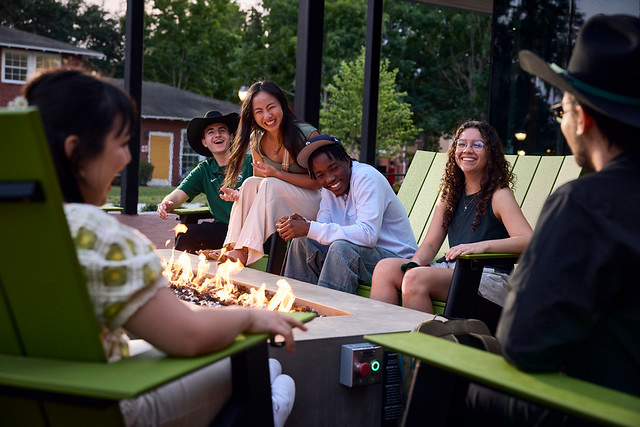 Students sit in front of a firepit