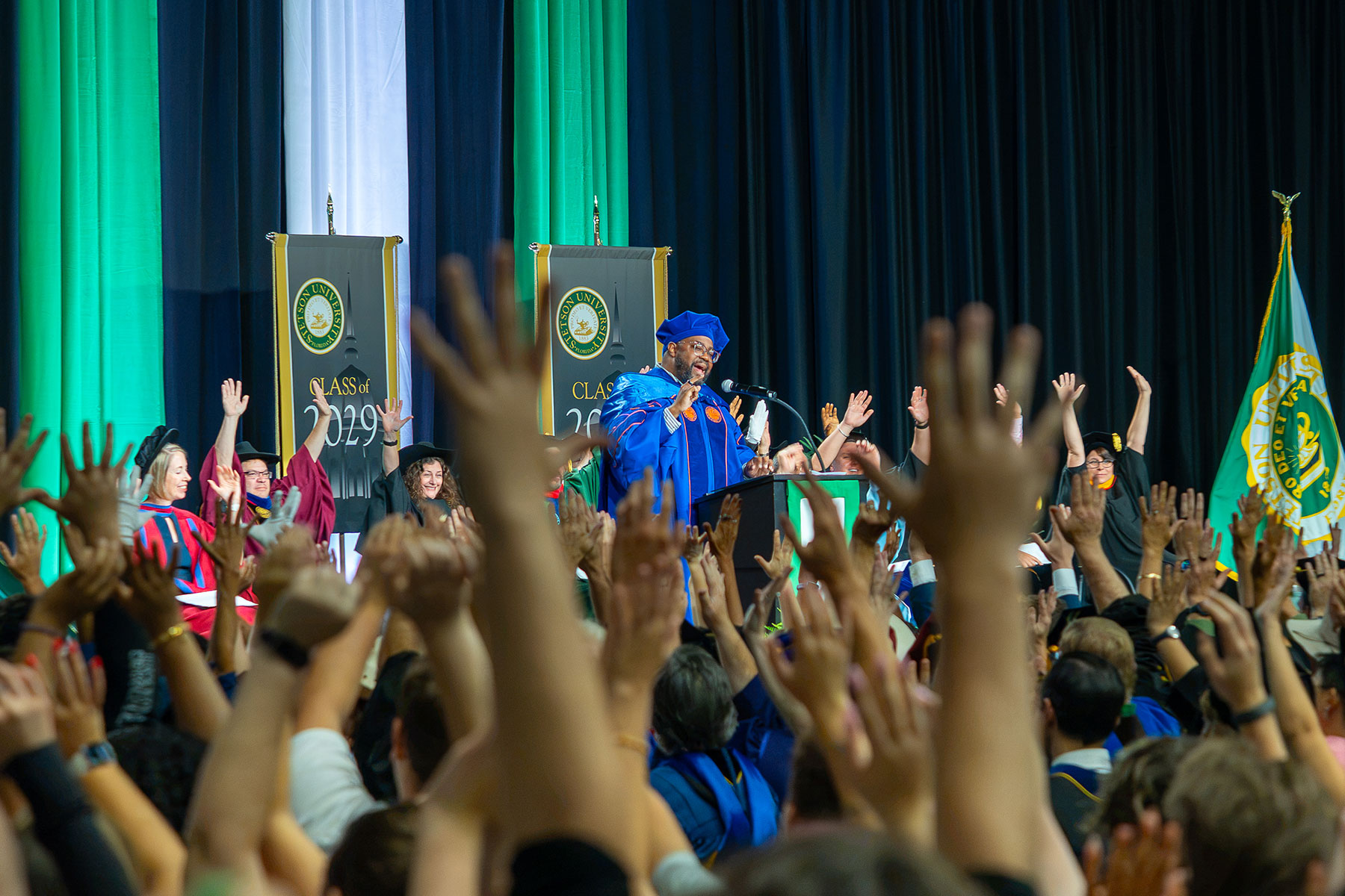 Randall Croom urges the audience to raise their hands during his address at Stetson's Convocation 2026