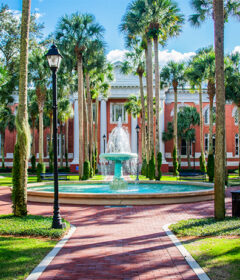 A fountain sits in a pretty campus scene