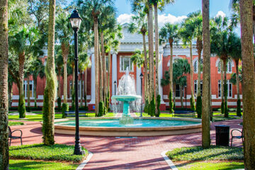 A fountain sits in a pretty campus scene