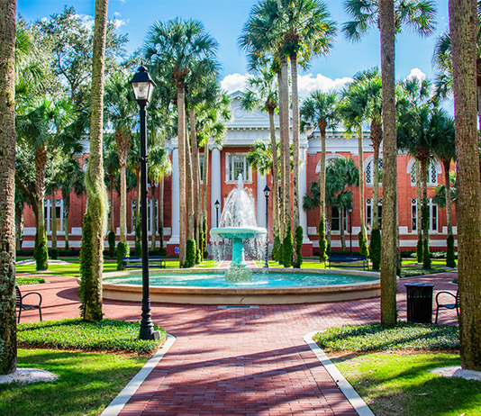 A fountain sits in a pretty campus scene