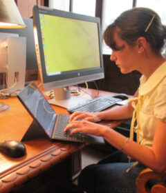 A woman works at her computer in a library