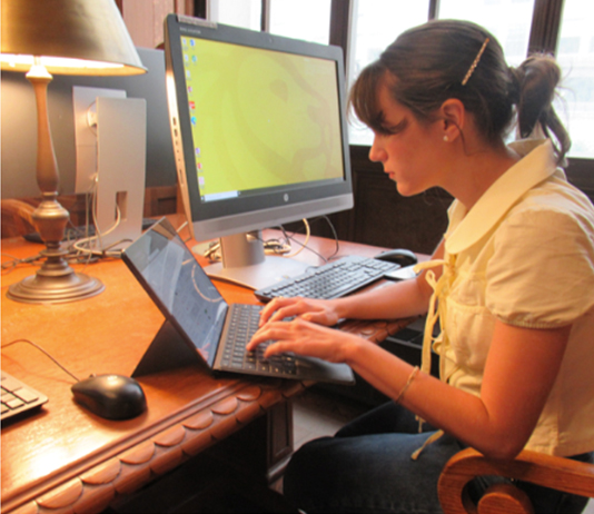 A woman works at her computer in a library