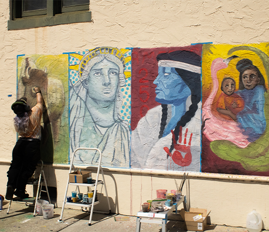 A student painting a mural