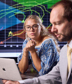 Professor and student working together in a trading room