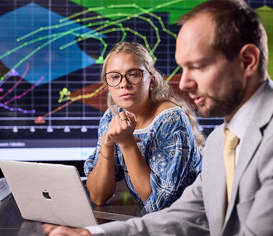 Professor and student working together in a trading room