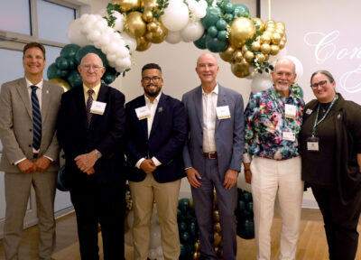 university president and alumni with president of alumni board